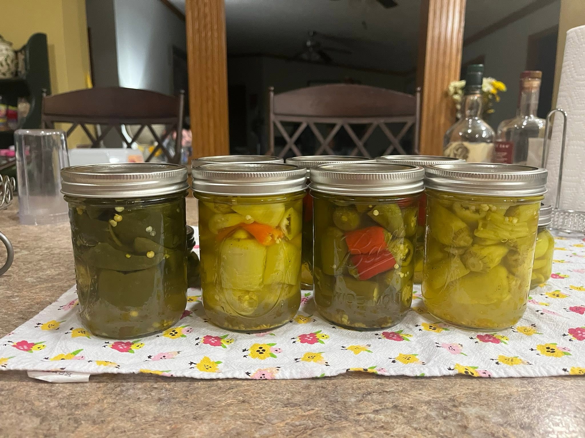 Jars of home-canned peppers on a kitchen counter